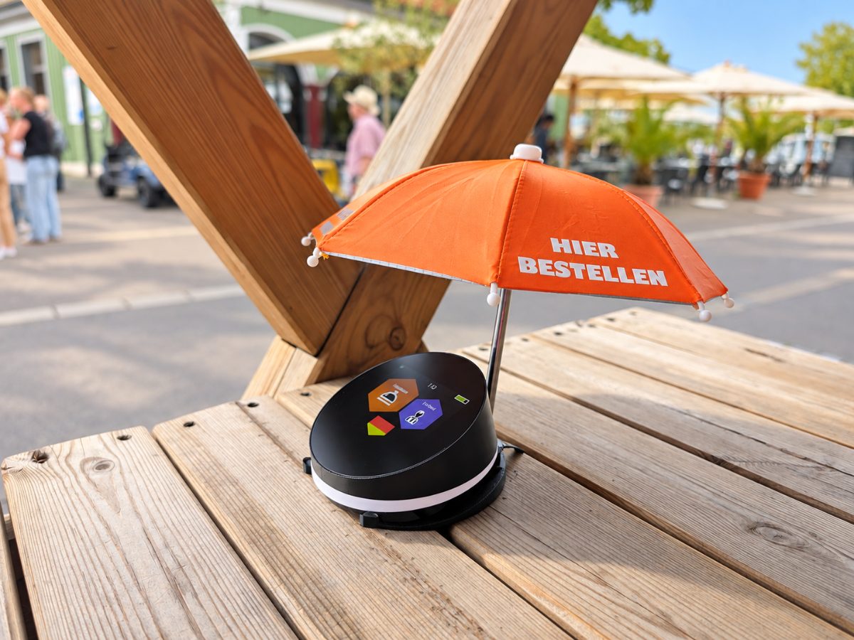 OrdiBee mit Bestellschirm auf dem Stehtisch im Außenbereich, Terrasse im Hintergrund